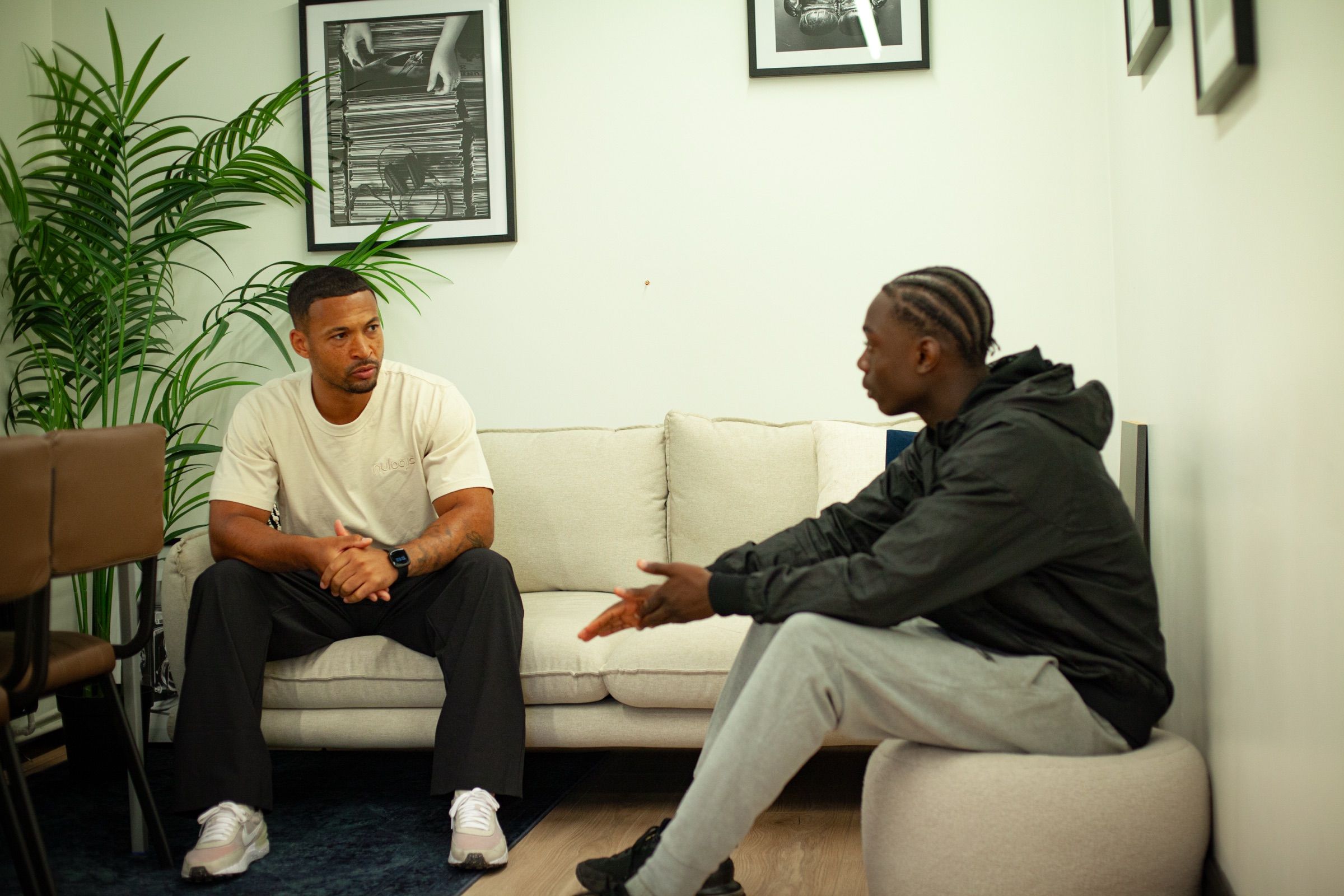 A Nulogic mentor listens as a young person talks, sitting together in a bright room.